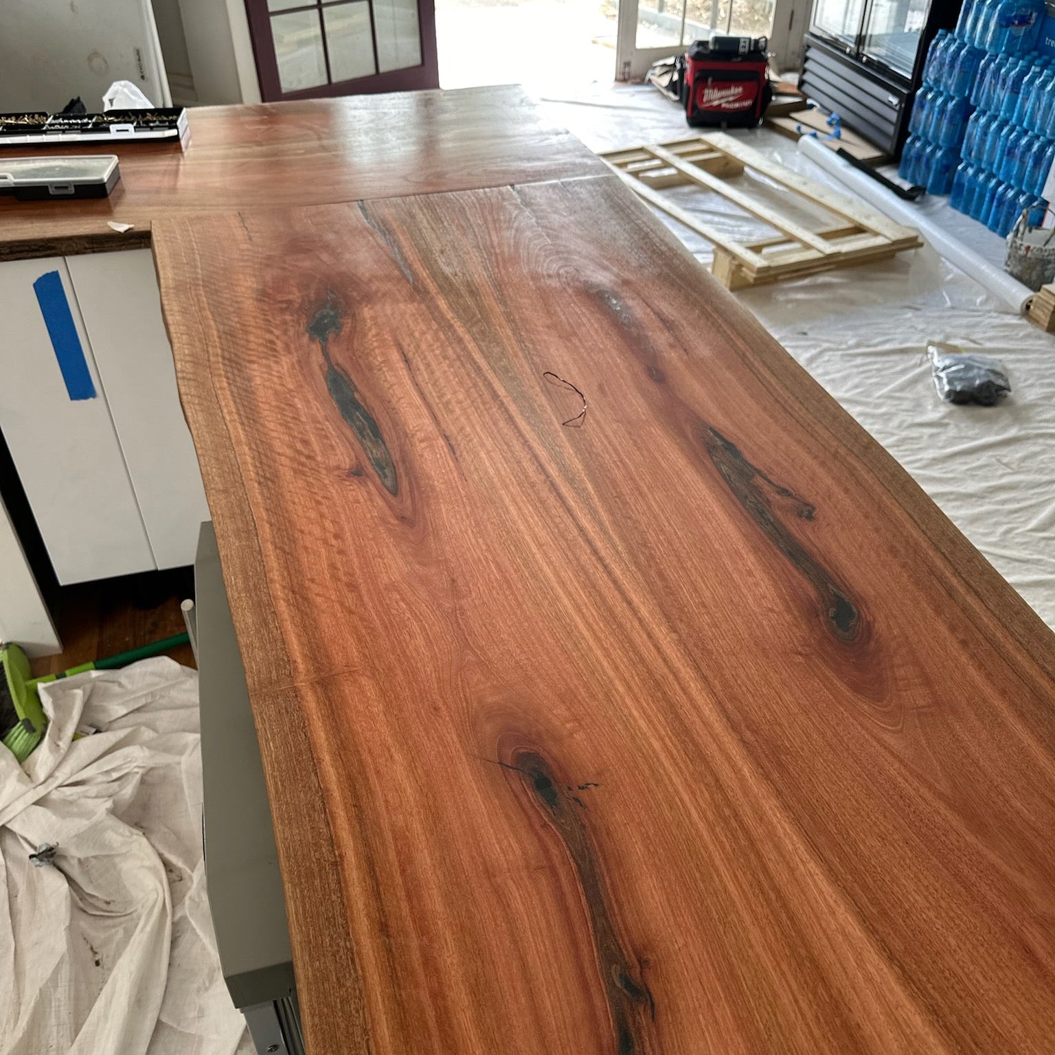 Wooden table in a workshop setting with tools and materials in the background